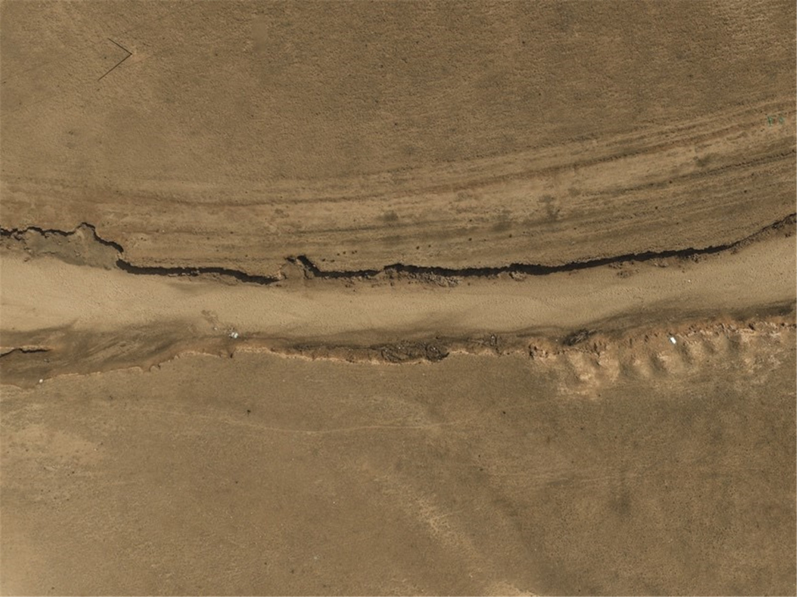 一张被沙子和灰尘侵蚀的干涸河流的航拍照片。