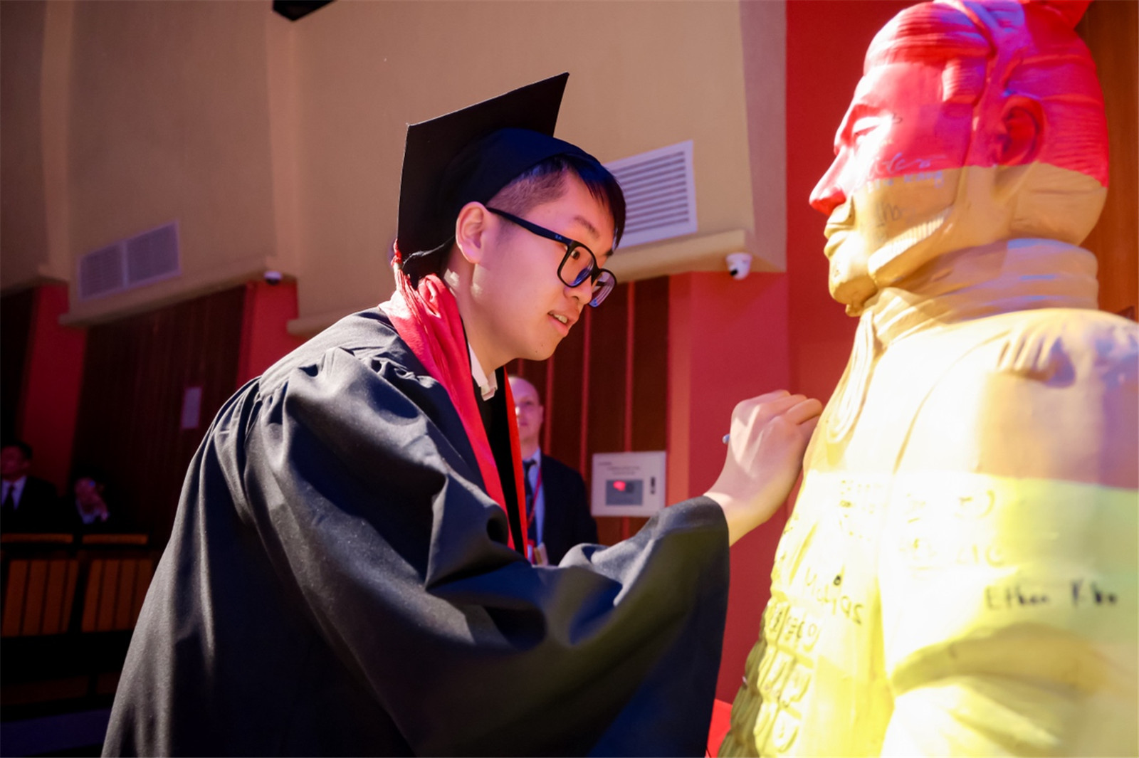 Brian signs his name onto the Terracotta Warrior during the Graduation Ceremony