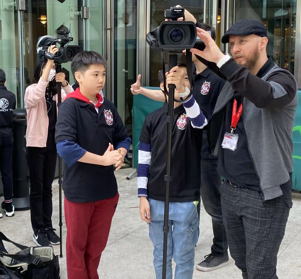 Alex guides the Dulwich TV crew to film a documentary in the School Fair