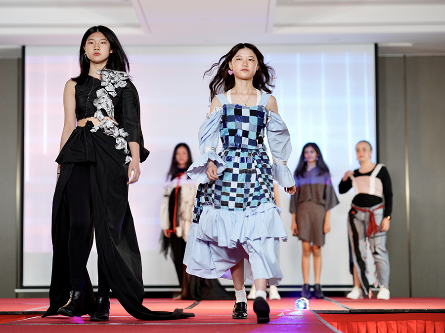 中学生领导的环保服装秀在“珍惜盘中餐”的活动中走秀