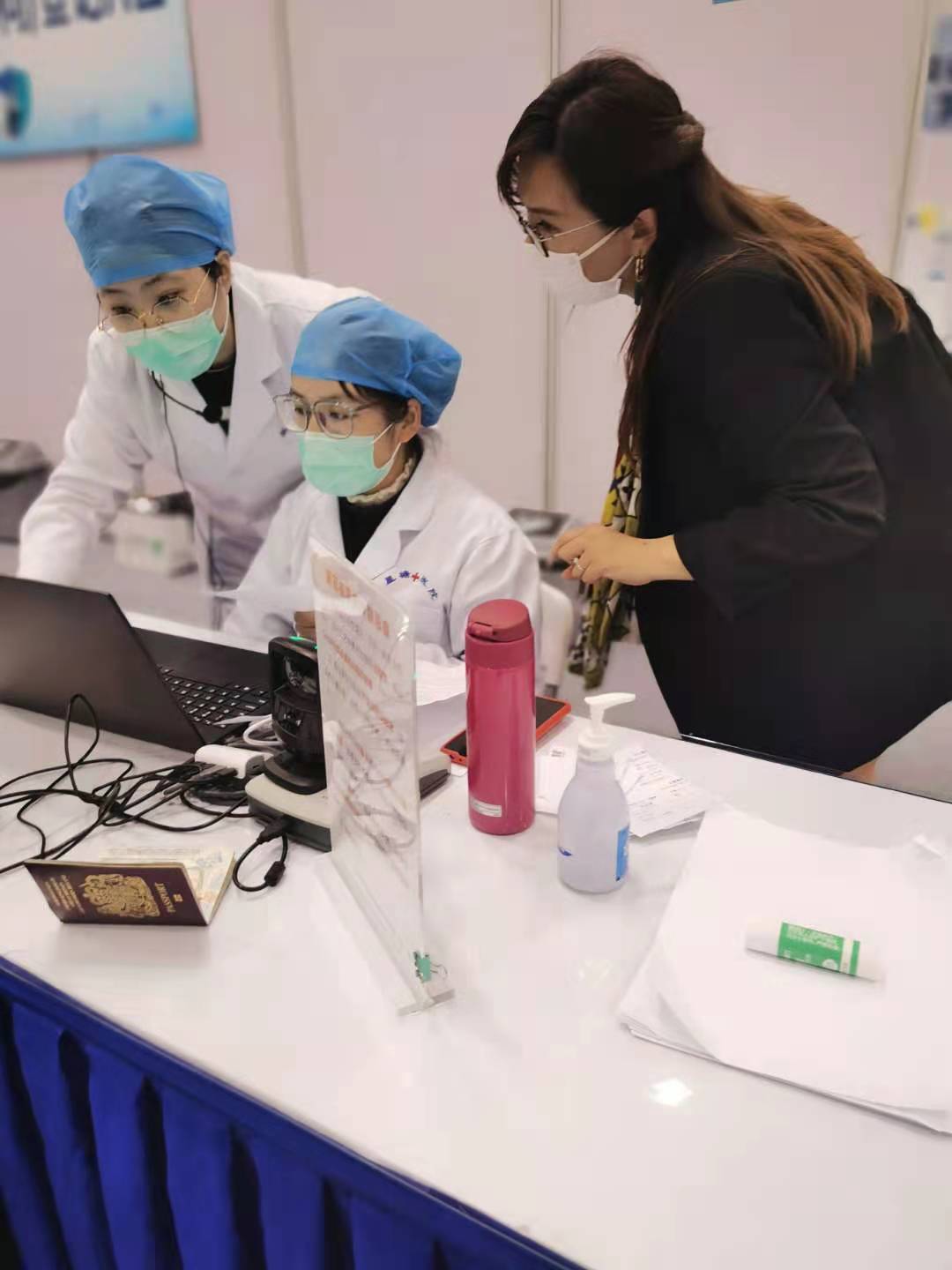 苏州德威外籍人员子女学校行政副校长Ann Ng(右) 与医护人员交谈