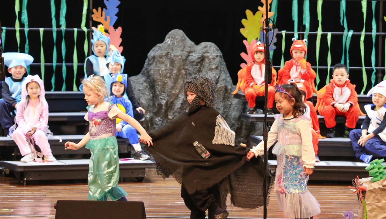 Drama students from Dulwich Shanghai Puxi in reception years are performing on stage in costumes