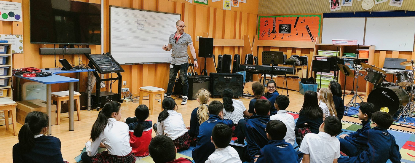 Roo Pigott leading a songwriting and music producing workshop with Dulwich College International students