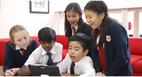 School Children gathered around laptop